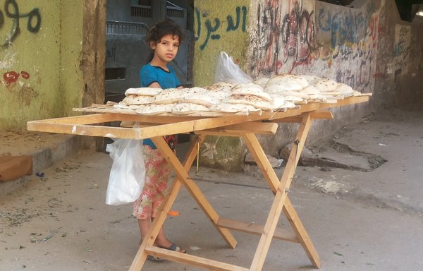 دختری در قاهره در حال فروش نوعی نان است که به آن یارانه دولتی تعلق نمی گیرد. [ولید ابوالخیر/المشارق]