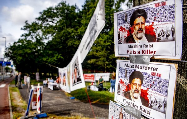 Placards depicting Ebrahim Raisi are displayed by demonstrators during a two-day protest against the Iranian president, in front of the temporary housing of the House of Representatives in The Hague, on September 13. The demonstrators consider Raisi partly responsible for poverty, oppression and executions in Iran. [Robin Utrecht/ANP/AFP]