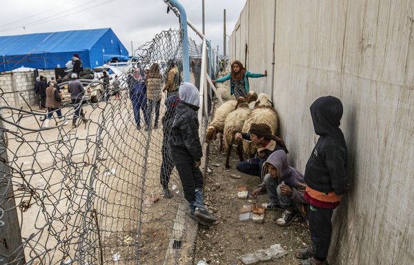 Syrian children eat as they get ready to leave al-Hol camp in al-Hasakeh province, where the relatives of alleged ISIS fighters are held, on November 16, 2020. [Delil Souleiman/AFP]