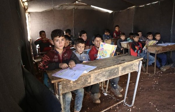 Syrian children displaced from their villages attend the school at al-Tah camp where they reside: a tent, with a dirt floor. [Ali Haj Suleiman]