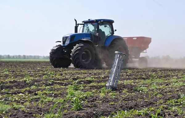 A tractor rides past a fragment of Russian missile on a field not far from Ukrainian city of Kharkiv, on May 8. [Sergey Bobok/AFP]