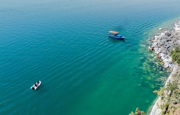 This picture taken on June 3 shows an aerial view of a boat moored off Qalaat Jaabar in Syria's Lake Assad reservoir in al-Raqa province. [Delil Souleiman/AFP]