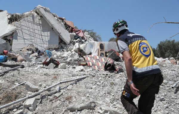 A member of the White Helmets walks on the rubble of a house following a Russian air strike on the outskirts of the Idlib province city of Jisr al-Shughur on July 22. Seven people, four of them children, were killed, and a dozen more were wounded. [Omar Haj Kadour/AFP]