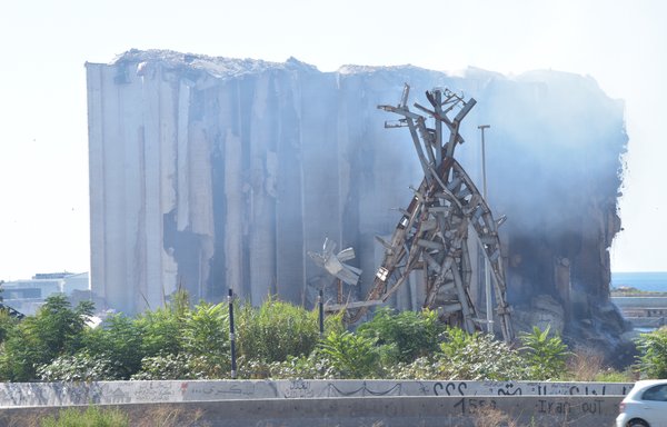 Smoke blankets what remains of Beirut port's wheat silos, which were destroyed in the 2020 explosion. A monument commemorating the explosion is seen in the foreground. [Ziad Hatem/Al-Mashareq]