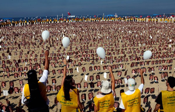 Members of the Bahai faith demonstrate on Copacabana beach in Rio de Janeiro, Brazil, on June 19, 2011, asking Iranian authorities to release seven Bahai prisoners accused of espionage. [Carolina Fernandes/AFP]