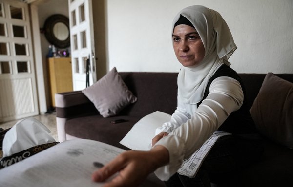 اللاجئة السورية راميا الصوص تتفقد وثائق عائلتها في شقتها بسهل البقاع اللبناني بتاريخ 13 حزيران/يونيو. [ديلان كولينز/وكالة الصحافة الفرنسية]