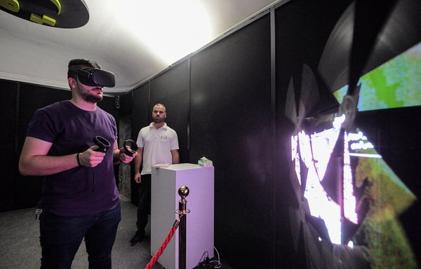 A visitor donning 3D goggles views reconstructed models of ancient artefacts destroyed during the occupation of Mosul by 'Islamic State of Iraq and Syria' (ISIS) group fighters, at the 'QAF Lab' (representing the Arabic letter 'qaf') Virtual Museum in Mosul on August 3. The Mosul museum is using virtual reality to let visitors explore ravaged heritage sites in northern Iraq as they appeared before ISIS unleashed a wave of destruction. [Zaid al-Obeidi/AFP]