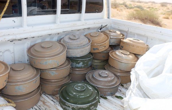 Defused land mines, reportedly planted by the Houthis, are stacked in the back of a truck as a pro-government specialist clears an area on the outskirts of Bayhan in Shabwa province, Yemen, on January 19. [Saleh al-Obeidi/AFP]
