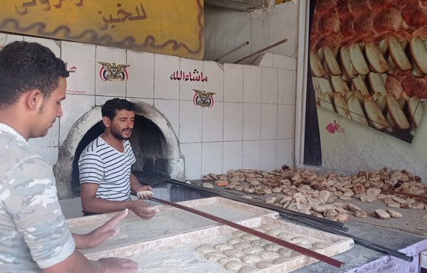 شهریور است و نانواها در نانوایی السنابل در بخش الاصبحی صنعا قرص‌های نان را برای پخت آماده می‌کنند. افزایش قیمت گندم به‌دلیل تجاوز روسیه به اوکراین باعث افزایش قیمت نان در یمن شده است. [نانوایی السنابل]