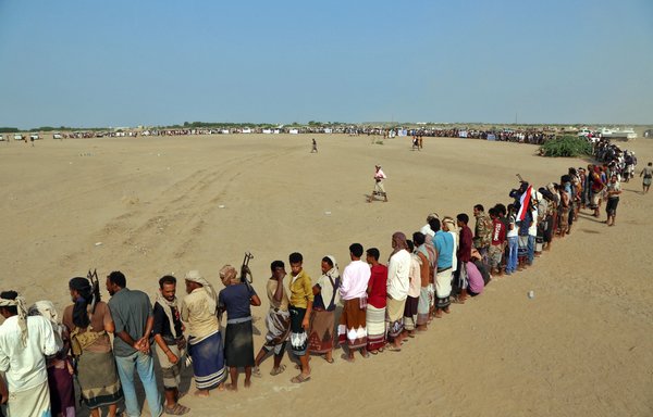 Armed militants gather for a protest against the Houthis near the al-Hodeidah province town of al-Khokha on September 20. [Khaled Ziad/AFP]