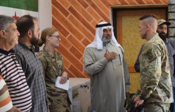 وفد من التحالف الدولي خلال زيارته لمخيم الركبان يوم 24 أيلول/سبتمبر واجتماعه مع وجهاء المخيم وقيادة جيش مغاوير الثورة لتحديد احتياجات سكانه الإنسانية. [جيش مغاوير الثورة]