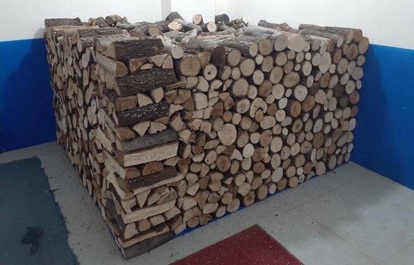 يكدس التاجر إلياس نعيمة مخزون الحطب بعد قطعه بموجب ترخيص من وزارة الزراعة لبيعه للمواطنين. [نهاد طوباليان/المشارق]