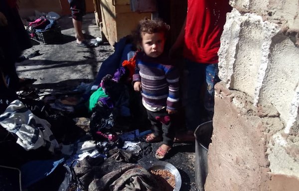 A child stands amid the charred remains of a tent after a fire broke out on the morning of October 5 in al-Wafa al-Omani camp in the Lebanese town of Arsal, destroying a large number of tents and displacing the families living in them. [The Voice of Syrian Refugees in Lebanon]