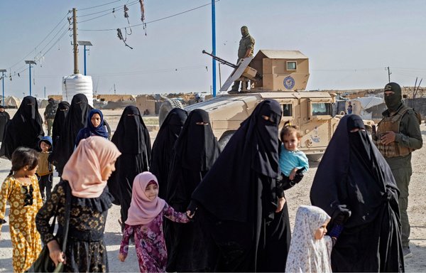 A picture shows women and children inside al-Hol camp in northeastern Syria's al-Hasakeh province, during a security operation carried out by Kurdish forces on August 26. [Delil Souleiman/AFP]