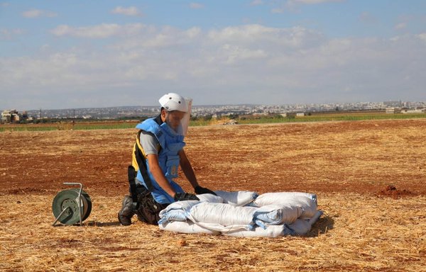 A member of the White Helmets de-mining team carries out his work in a field on October 10. [White Helmets]