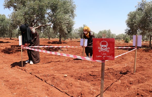 Two members of the White Helmets respond to the discovery of cluster bombs in an agricultural field on September 26. [White Helmets]