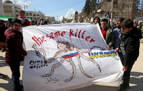 Syrians hold a banner expressing solidarity with the Ukrainian people during a rally in Idlib on March 15, marking 11 years since an anti-regime uprising. [Omar Haj Kadour/AFP]