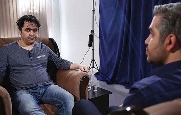 وراء الكواليس أثناء ʼاعترافاتʻ روح الله زام المتلفزة في العام 2020. ويجلس علي رضواني من إذاعة الجمهورية الإسلامية في إيران أمام زام وظهره إلى الكاميرا. وقد أعدم روح الله زام بعد شهرين من ذلك. [تسنيم]