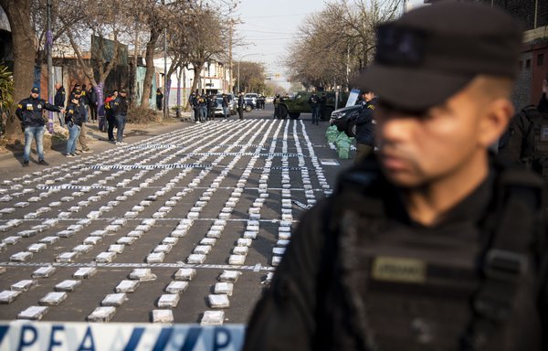 نیروهای پلیس روز ۴ شهریور در روزاریو، آرژانتین، مراقب بسته‌های کوکائین توقیف‌شده هستند. افسران پلیس فدرال یک محموله ۱۶۰۰ کیلوگرمی کوکائین به ارزش تقریبی ۶۰ میلیون دلار را که در آستانۀ حرکت از یک مسیر آبی به‌سوی دبی بود، کشف کردند. [خبرنگار/خبرگزاری فرانسه]