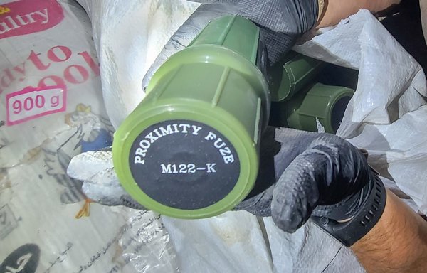 A member of the US military holds a proximity fuse seized from a fishing trawler interdicted by the US Navy on December 1 in the Gulf of Oman with a cargo of ammunition and rocket propellant. [US Navy]