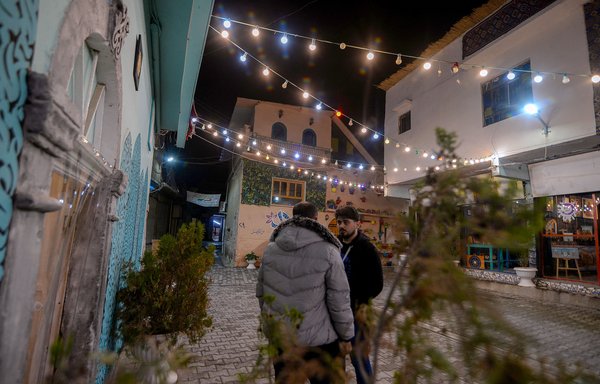 عراقيون يقفون في منطقة أعيد إعمارها في مدينة الموصل القديمة التي دمرتها الحرب في 30 تشرين الثاني/نوفمبر. ولكن على غرار معظم مدن العراق الغني بالنفط والذي دمرته الحرب، لا تزال الخدمات العامة المتداعية والصعوبات الاقتصادية الكبيرة تعرقل الحياة اليومية في الموصل. [زيد العبيدي/وكالة الصحافة الفرنسية]