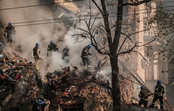 Ukrainian firefighters work on a destroyed building after a drone attack in Kyiv on October 17, amid the Russian invasion of Ukraine. Iranian drones have been used in many of the attacks. [Yasuyoshi Chiba/AFP]