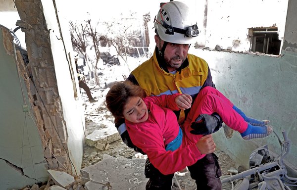 A member of the Syrian Civil Defence, also known as the White Helmets, carries a wounded girl following a reported Russian air strike in the village of Tal Mardikh in northwestern Idlib province, Syria, on December 19, 2019. [Omar Haj Kadour/AFP]