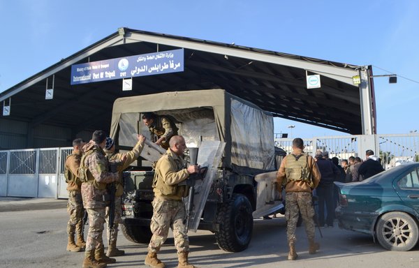 Members of the Lebanese army deploy as families await news of their relatives at the entrance of the port in Tripoli on January 1, following a rescue operation by the navy of a sinking migrant boat in Mediterranean waters, off Lebanon's northern coast. [Fathi al-Masri/AFP]