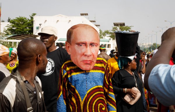 أحد أنصار الرئيس المالي المؤقت أسيمي غويتا يرتدي قناعا للوجه يحمل صورة الرئيس الروسي فلاديمير بوتين، وذلك أثناء مسيرة مؤيدة للمجلس العسكري وروسيا في باماكو يوم 13 أيار/مايو. [عثمان ماكافيلي/وكالة الصحافة الفرنسية]