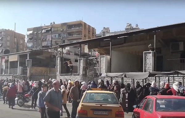 Syrians stand in long queues in front of bakeries, after the government lifted the subsidies on bread, in 2021. [Syria TV]