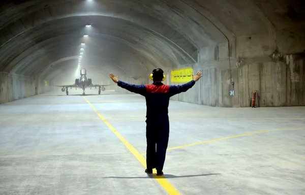 A man directs a plane inside an underground base in Iran in a photo posted on February 8. [File]