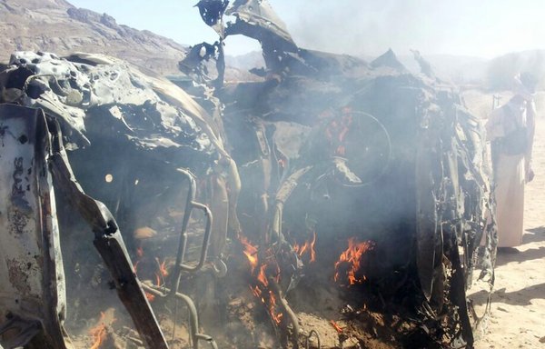 Yemenis gather around a car after it was targeted by a drone strike killing three suspected al-Qaeda militants on January 26, 2015, between Marib and Shabwa provinces. [AFP/STR]