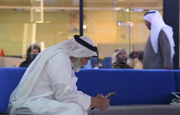 تاجر يدقق في هاتفه الذكي في دبي. تتزايد المخاوف في الإمارات حيث وقعت هواوي اتفاقية في عام 2022 ’للتعاون في تعزيز الاستراتيجيات السيبرانية المحلية‘. [كريم صاحب/وكالة الصحافة الفرنسية]