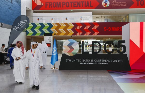 در پنجمین کنفرانس سازمان ملل متحد پیرامون کشورهای کمتر توسعه‌یافته که ۱۳ اسفند در دوحه برگزار شد، نمایندگان اطراف مرکز ملی همایش‌های قطر قدم می‌زنند. [کریم جعفر/خبرگزاری فرانسه]