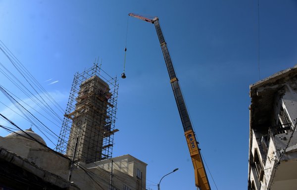A photo taken February 28 shows one of three bells cast in Normandy, France, being lifted to the top of the bell tower of the Roman Catholic Dominican Church of Our Lady of the Hour in Mosul. [Zaid al-Obeidi/AFP]