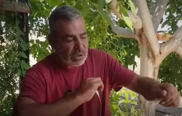 في لقطة شاشة من شريط فيديو بثت على موقع يوتيوب، يقوم المقاتل السابق في حزب الله حسن محمود محسن بتمزيق صور له مع زعيم الحزب حسن نصر الله.