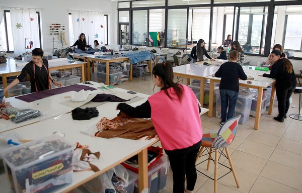 Iraqi women work at the atelier of Rafedin, a sewing project set up by Italians to help Iraqi refugee women in Jordan, at St. Joseph Catholic church in Amman, on March 12. [Khalil Mazraawi/AFP]
