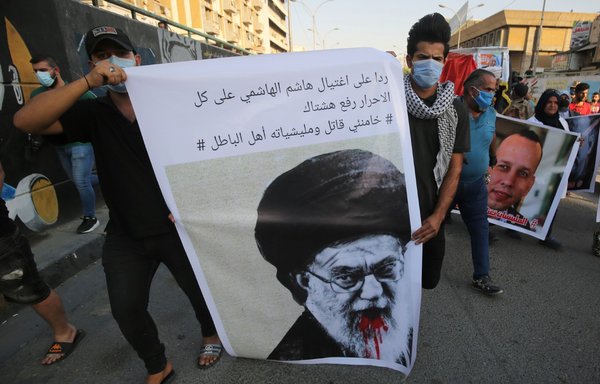 تظاهرکنندگان عراقی در روز ۱۷ تیر ۱۳۹۹ در میدان تحریر بغداد در مراسم خاکسپاری نمادین هشام الهاشمی، کارشناس مسائل افراط‌گرایی در عراق، شرکت کردند. شعار این مراسم به زبان عربی: «در پاسخ به قتل هشام الهاشمی، همۀ انسان‌های آزاد باید از هشتگ "خامنه‌ای قاتل و شبه‌نظامیان او اهل باطل" استفاده کنند». [احمد الرباعی/خبرگزاری فرانسه]