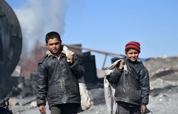 Syrian teenagers work at a makeshift oil refining installation near the city of al-Bab in the north of Aleppo province, on March 28, 2022. The Russian-backed, pro-Syrian regime Qaterji militia has been actively recruiting minors in Deir Ezzor province to work for meagre stipends. [Rami al-Sayed/AFP]