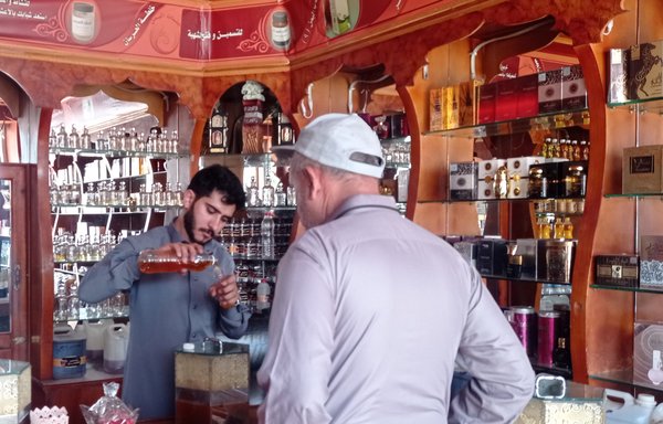 بائع عسل يعرض على أحد العملاء أنواعا مختلفة من العسل اليمني في محل لبيع العسل بصنعاء في حزيران/يونيو. [هيثم محمد/المشارق]