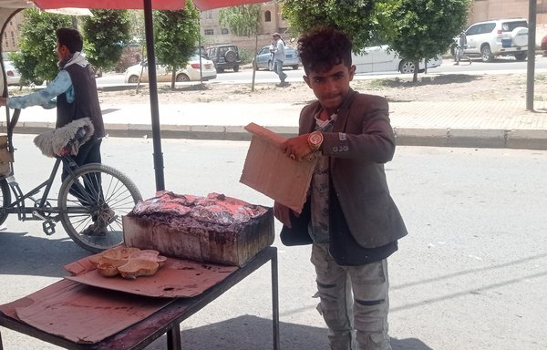 Mohammed Ahmed, 10, dropped out of school and entered the labour market to help his family, selling barbecued meats in Sanaa. [Haytham Mohammed/Al-Mashareq]