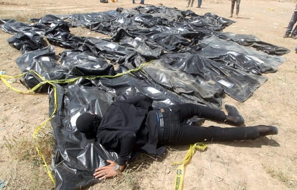 عراقي يصرخ فوق أكياس تضم رفات أشخاص يعتقد أنهم ذبحوا على يد تنظيم داعش في أرض معسكر سبايكر في مدينة تكريت العراقية، وذلك يوم 12 نيسان/أبريل 2015. [أحمد الربيعي/وكالة الصحافة الفرنسية]