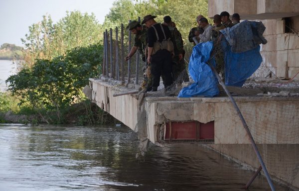 قوات الأمن العراقية تفتش واجهة على نهر دجلة في تكريت يوم 1 نيسان/أبريل 2015 يعتقد أنها كانت مسرح مجزرة معسكر سبايكر التي وقعت في حزيران/يونيو 2014، وراح ضحيتها مئات الطلاب العسكريين على يد تنظيم داعش. [يونس البياتي/وكالة الصحافة الفرنسية]